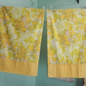 Pode incluir: Um par de fronhas amarelas com flores e uma borda amarela s&oacute;lida. As fronhas t&ecirc;m um padr&atilde;o floral vintage com flores amarelas, verdes e rosas.