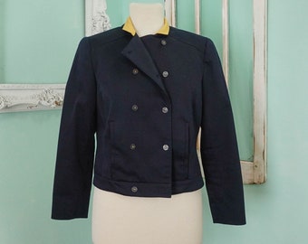 May include: A navy blue cropped blazer with a double-breasted closure and a yellow collar.