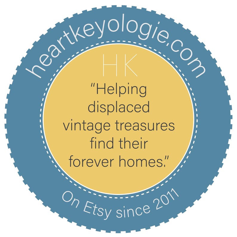 Pode incluir: Um logotipo circular com uma borda azul e um centro amarelo. O texto "heartkeyologie.com" est&aacute; em arco na parte superior. No interior, l&ecirc;-se "HK" e "Helping displaced vintage treasures find their forever homes." A parte inferior diz "On Etsy since 2011."