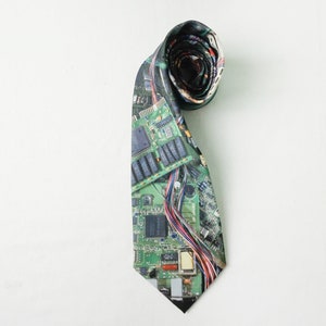 May include: A green, black, and red tie with a circuit board pattern.