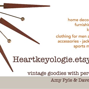 May include: A business card with a vintage clock design and the text "Heartkeyologie.etsy.com" and "vintage goodies with personality Amy Pyle & Dave Conover". The card lists items for sale, including home decor, bedding, furnishings, lamps, kitchenware, clothing for men and women, accessories, jackets, shoes, and sports memorabilia.