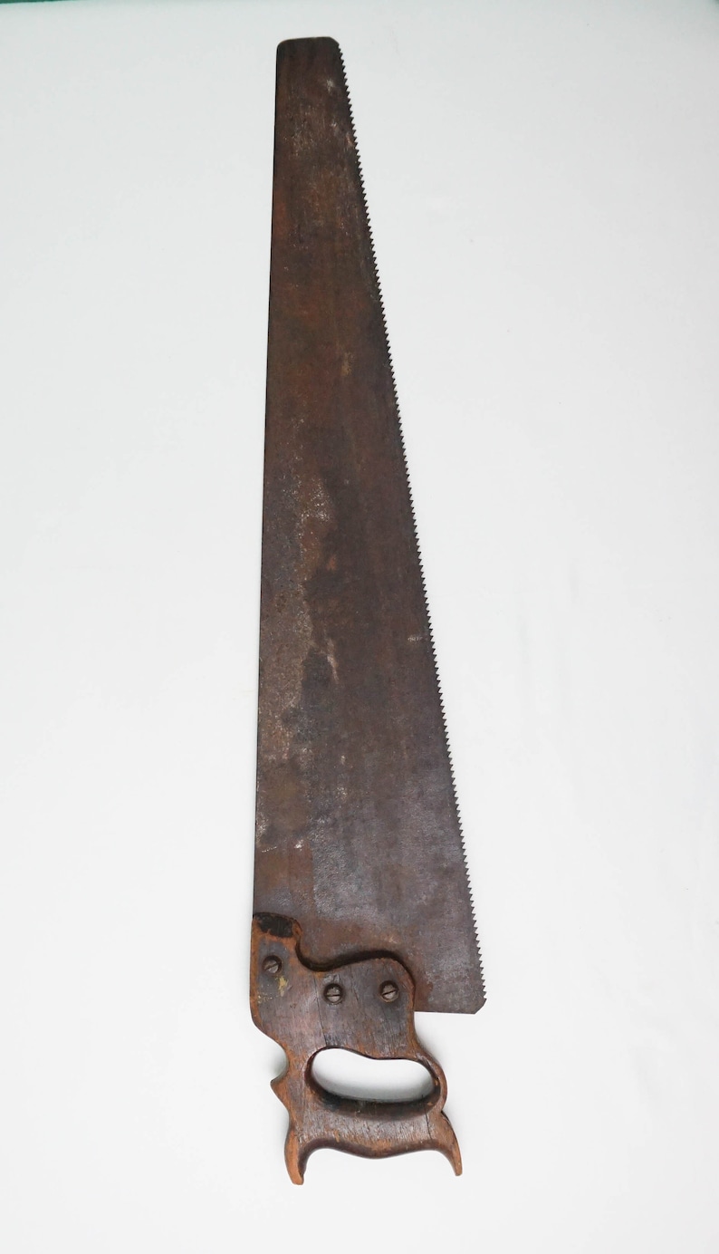 May include: A vintage hand saw with a wooden handle and a rusty metal blade.
