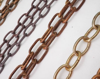 May include: Four different chains, each with a different finish: gold, brass, copper, and gray. The chains are all made of metal and have a classic link design.