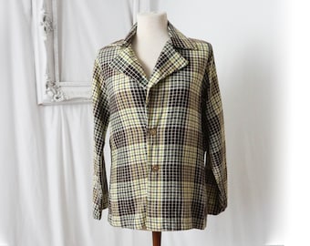 May include: A long-sleeved plaid jacket with a brown, yellow, and white plaid pattern. The jacket has a collar and a button closure.