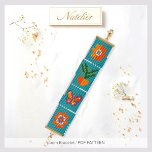 May include: A rectangular loom bracelet featuring a teal background with a repeating pattern of orange flowers, a green potted plant, and an orange butterfly. The bracelet has gold-toned metal end bars with a lobster clasp and a jump ring attachment.