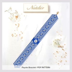 May include: A long, flat peyote bracelet featuring a geometric pattern of blue, white, and black seed beads. The design consists of repeating chevron and diamond shapes. A gold-toned metal clasp is attached to one end of the beaded strip.