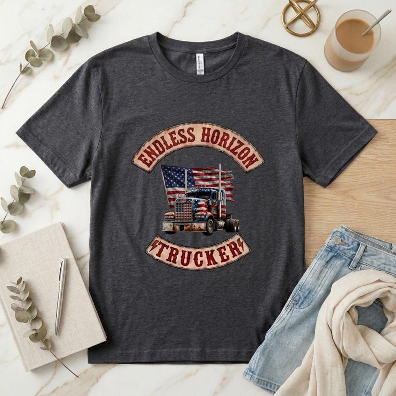 May include: A dark charcoal grey short-sleeve t-shirt featuring a graphic of a semi-truck with an American flag design. The text "ENDLESS HORIZON" appears in an arched banner above the truck, and "TRUCKER" is printed in a banner below the truck.