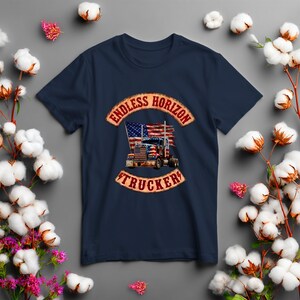 May include: A navy blue t-shirt featuring a graphic print of a semi-truck with an American flag design. The graphic is framed by two curved banners with the text ENDLESS HORIZON at the top and TRUCKER at the bottom in a distressed red font.