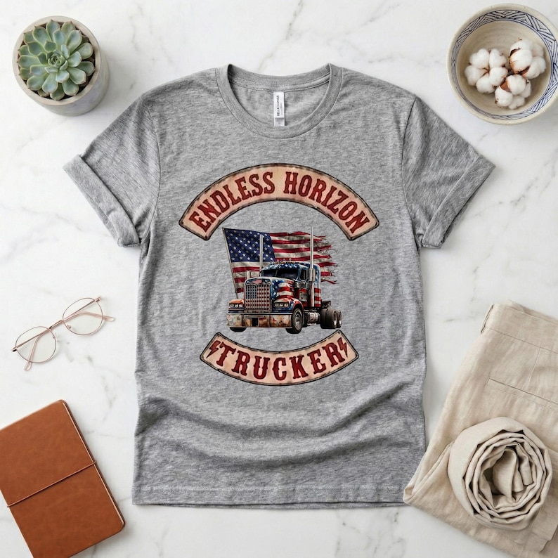 May include: A heather grey short-sleeved t-shirt featuring a graphic print of a semi-truck overlaid with an American flag. The design includes the text ENDLESS HORIZON TRUCKER in a curved banner style, with a distressed, vintage-inspired aesthetic.