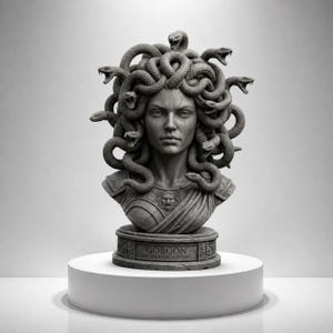 May include: A grey bust of Medusa, the Gorgon, with snakes for hair. The sculpture is on a white plinth, with the word "Gorgon" inscribed on the base. The bust is a classical sculpture.