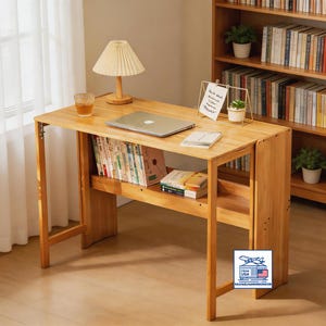 May include: A light-colored wooden desk with a laptop, books, and a lamp. The desk has a built-in shelf and is positioned in front of a bookshelf. A glass of liquid sits on the desk.