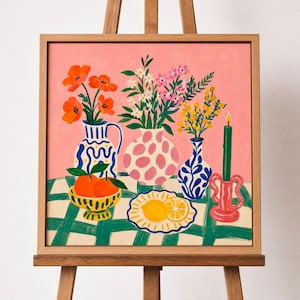 May include: A framed still life painting featuring vases of flowers, a bowl of oranges, and a plate with a lemon slice. The painting has a pink background and a green and white checkered tablecloth.