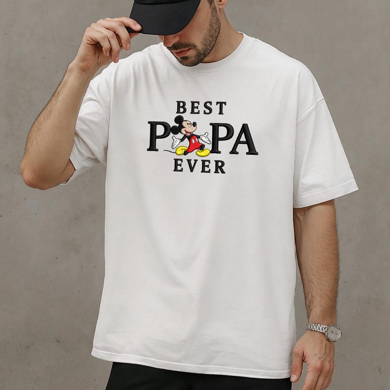 Puede incluir: Camiseta blanca con el texto negro "BEST PA EVER", con un dibujo animado de Mickey Mouse. La camiseta es de estilo casual y de gran tama&ntilde;o.