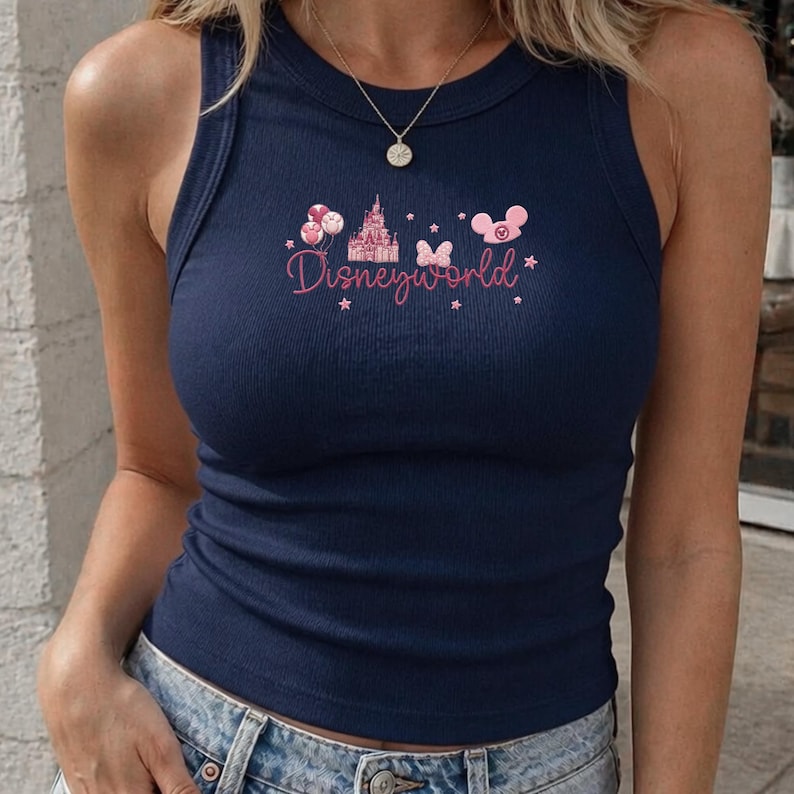 Peut inclure: D&eacute;bardeur c&ocirc;tel&eacute; bleu marine avec un motif rose "Disneyworld". Le motif comprend un ch&acirc;teau, des ballons, un n&oelig;ud et une t&ecirc;te de Mickey Mouse. Le d&eacute;bardeur est sans manches et a une encolure ronde.