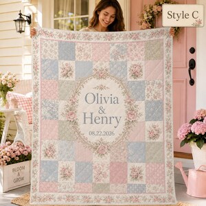 May include: A patchwork quilt featuring a floral and striped pattern in shades of pink, blue, and green. The center displays an oval frame with the text Olivia & Henry and the date 08.22.2026. The quilt has a decorative border with floral motifs.