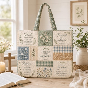 May include: A quilted tote bag featuring a patchwork design with floral patterns, plaid accents, and printed religious scripture verses including Trust in the Lord, Fear not, The Lord is my shepherd, Rejoice, and I know the plans in black text.