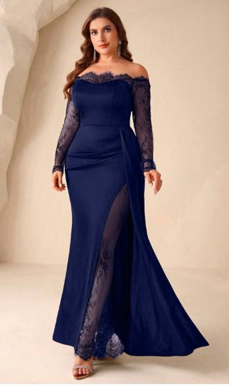 May include: A floor-length navy blue gown featuring an off-the-shoulder neckline with delicate lace trim, long sheer lace sleeves, and a high side slit that reveals a sheer lace panel underneath the solid fabric skirt, creating a layered effect.