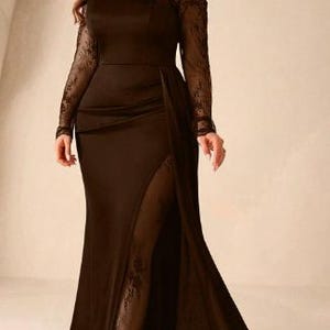 May include: A floor-length dark brown gown featuring an off-the-shoulder neckline with delicate lace trim, long sheer lace sleeves, and a high side slit that reveals a lace-lined panel extending down to the hem of the skirt.