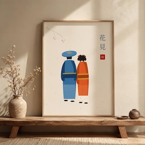 May include: A framed wall art print featuring a minimalist illustration of two figures viewed from behind. One figure wears a blue robe and hat, the other an orange robe. The print includes a thin branch with pink buds and Japanese text.