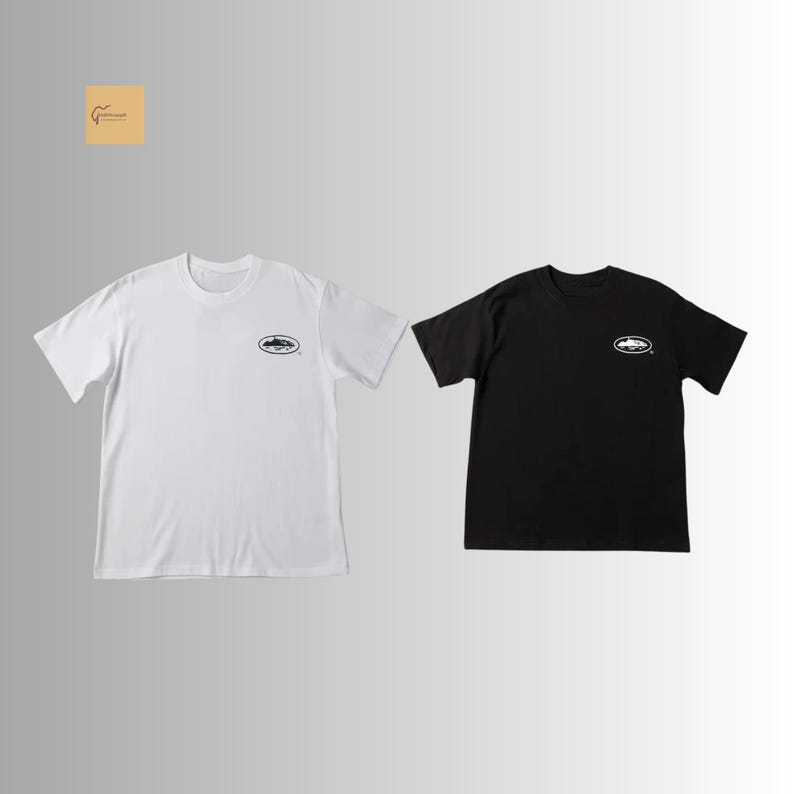 May include: A white short-sleeved t-shirt and a black short-sleeved t-shirt, both featuring a small oval graphic on the left chest. The white shirt has a black oval logo, while the black shirt has a white oval logo, each with a central illustration.