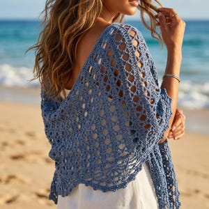 May include: A dusty blue crochet shawl featuring an openwork diamond pattern with a scalloped edge. The garment is draped over the shoulders, showcasing a lightweight, airy construction with intricate yarn loops and a soft, textured finish.