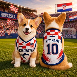 May include: Two tan and white Corgi dogs wearing matching sleeveless jerseys featuring the red and white checkered Croatian flag pattern. The front jersey displays the text CROATIA, while the back jersey shows PET NAME and the number 10.