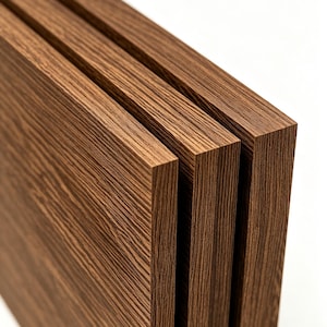 May include: Three rectangular wooden boards with a dark brown finish and a visible linear wood grain pattern. The boards are positioned parallel to each other, showcasing their thickness and the layered texture of the wood material on the edges.