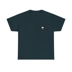 May include: Dark teal t-shirt with a small graphic of a pint of stout beer on the left chest. The beer graphic is black with white foam and the word "Guinness" on the side. The shirt is made of a soft material.