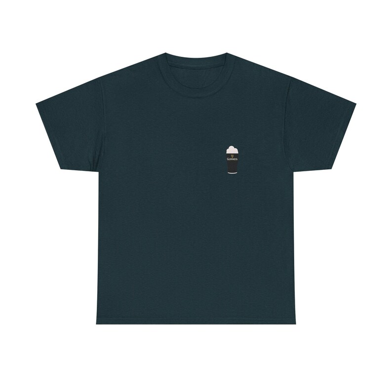 May include: Dark teal t-shirt with a small graphic of a pint of stout beer on the left chest. The beer graphic is black with white foam and the word "Guinness" on the side. The shirt is made of a soft material.