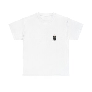 May include: White t-shirt featuring a small graphic of a pint of stout. The pint glass is black with a white foamy head. The shirt is made of a soft, comfortable material.
