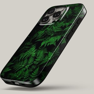 May include: A smartphone case featuring a dark background with a vibrant green fern leaf pattern. The case has a black frame, a camera cutout with three lenses, and side buttons. The design covers the back of the device, showing detailed foliage.