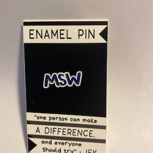 May include: An enamel pin on a black and white card. The pin features the letters "MSW" in blue. The card reads "ENAMEL PIN" at the top and a quote by JFK: "one person can make A DIFFERENCE, and everyone should try."