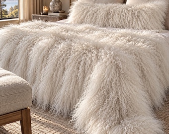 May include: A long, cream-coloured throw blanket with a thick, shaggy, curly texture draped over a bed. A matching long, rectangular bolster pillow with the same shaggy, curly cream-coloured texture is positioned at the head of the bed.
