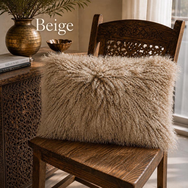 May include: A rectangular beige pillow with a long, shaggy, textured pile surface. The pillow features a central radiating pattern where the fibers extend outward from the middle. The word Beige is printed in white text above the pillow.