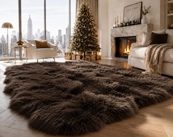 May include: A large, rectangular area rug featuring a deep, dark brown colour with a thick, shaggy, and textured pile. The rug has an irregular, organic shape with soft, rounded edges that cover a portion of the light-coloured wooden floor.