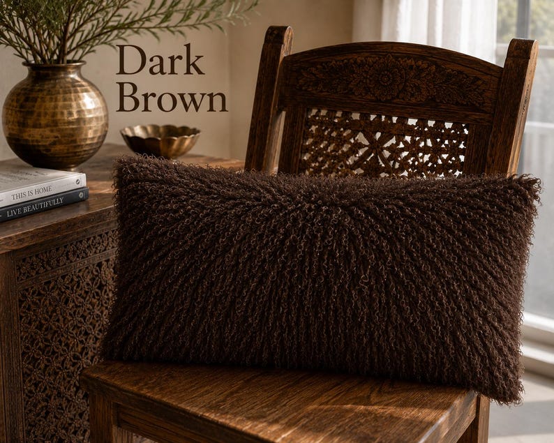 May include: A rectangular dark brown throw pillow with a shaggy, textured surface. The pillow features long, curly fibers covering the entire front face, creating a dense and uniform appearance. The text Dark Brown is visible in the image.