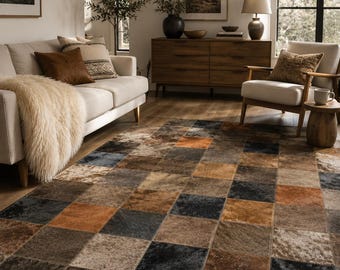 May include: A rectangular area rug featuring a patchwork design of square tiles in various shades of brown, tan, black, and grey. The rug has a textured surface with visible stitching between each square, creating a grid pattern across the floor.