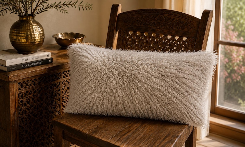 May include: A rectangular throw pillow with a long, shaggy, off-white faux fur texture. The pillow has a dense, fibrous appearance with a soft, fluffy pile that covers the entire front surface, creating a uniform and highly textured look.