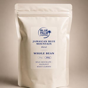 Puede incluir: Una bolsa de pie color crema de café en grano entero Blue Palm Coffee Jamaican Blue Mountain Blend. La etiqueta muestra un logotipo de palmera azul, opciones de 250g y 500g, y notas de sabor a chocolate con leche, avellana y almendra tostada.