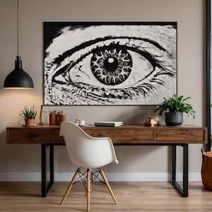 May include: A black and white eye art print hangs above a wooden desk with a white chair. The artwork features a detailed depiction of an eye. The desk has a black metal frame and is accessorized with plants and office supplies.