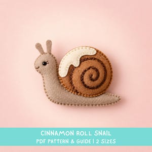 May include: A felt snail craft featuring a light tan body and a brown spiral shell topped with a white icing detail. The text at the bottom reads CINNAMON ROLL SNAIL PDF PATTERN & GUIDE | 2 SIZES. The snail has a small black eye.