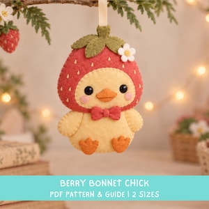May include: A felt hanging ornament shaped like a yellow chick wearing a red strawberry bonnet with a green stem and a small white flower. The chick has black eyes, pink cheeks, an orange beak, and a red bow tie. Text reads: BERRY BONNET CHICK PDF PATTERN & GUIDE | 2 SIZES