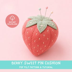 May include: A strawberry-shaped felt pin cushion with white embroidered seeds and a sage green leaf top featuring floral embroidery. Three sewing pins with colorful round heads are inserted into the top. Text reads INSTANT DOWNLOAD.