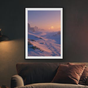 May include: A framed wall art print depicting a snowy landscape under a soft sunset sky. The scene features rolling white snow dunes with visible footprints leading into the distance, rocky formations, and a glowing sun on the horizon.