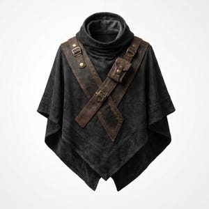 Può includere: Un poncho in camoscio grigio scuro con collo alto a lupetto. Il poncho presenta un'imbracatura in pelle marrone con una piccola tasca e fibbie in metallo. Il design ricorda l'abbigliamento medievale o fantasy.