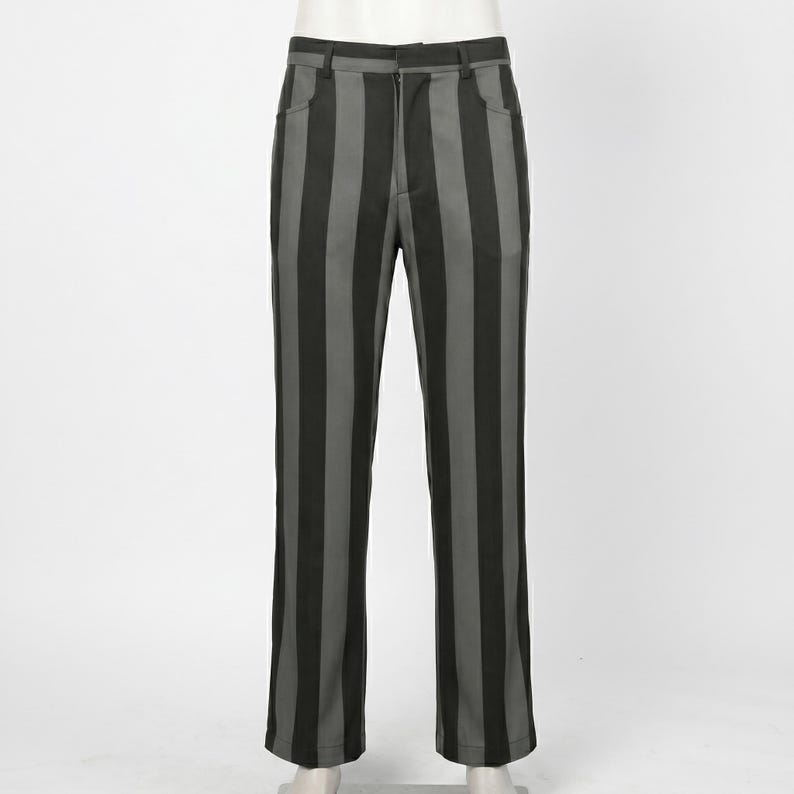 Peut inclure: Pantalon pleine longueur pr&eacute;sentant un motif &agrave; rayures verticales alternant des nuances de gris anthracite et de noir. Ce pantalon comprend une ceinture standard avec passants, une fermeture &eacute;clair sur le devant et deux poches lat&eacute;rales.