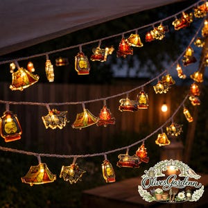 Könnte beinhalten: Eine dekorative LED-Lichterkette mit kleinen Camping-Motiven wie Zelten, Laternen, Lagerfeuern und Wohnmobilen. Die durchscheinenden, bunten Kunststoffformen werden von innen beleuchtet und erzeugen ein warmes Leuchten entlang des Kabels.