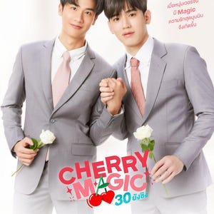 Op de afbeelding: Promotieposter voor "CHERRY MAGIC" met twee mannen in grijze pakken, die elkaars hand vasthouden en witte rozen vasthouden. De titel is in rood en roze, met Thaise tekst eronder.