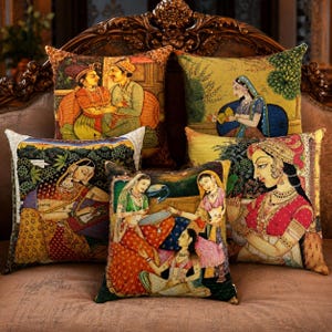 Peut inclure: Une collection de cinq coussins carrés présentant des illustrations détaillées et colorées de personnages en tenue traditionnelle. Les motifs représentent diverses scènes avec des personnes vêtues de vêtements ornés, de bijoux et de coiffes sur des fonds riches.