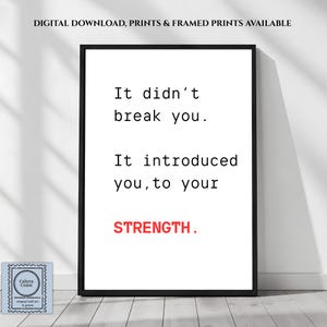 May include: A rectangular black-framed wall art print featuring white background with black text that reads: It didn't break you. It introduced you, to your STRENGTH. The word STRENGTH is printed in bold red capital letters at the bottom.